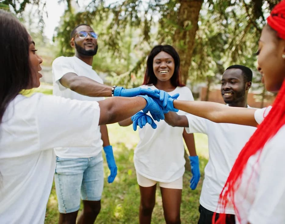 Community volunteers joining hands at a programme site